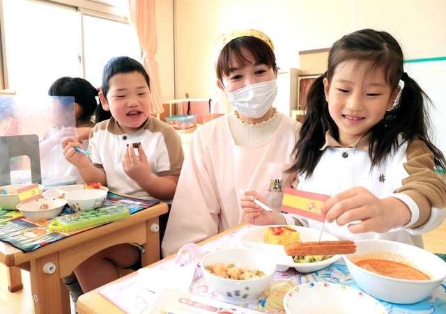 スペインの給食を食べる園児たち。栄養士の渡邊摩耶さん（右から２人目）が企画した＝神戸市長田区長田天神町１、名倉幼稚園