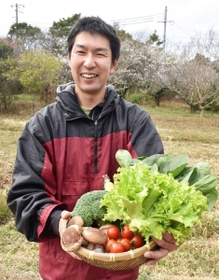 おしベジタブルで届ける野菜セットを手にする山崎高志さん＝神戸市西区
