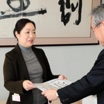 神戸新聞社の高梨柳太郎社長（左）から表彰状を受け取る「多文化共生センターひょうご」代表の北村広美さん＝神戸市中央区東川崎町１