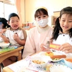 スペインの給食を食べる園児たち。栄養士の渡邊摩耶さん（右から２人目）が企画した＝神戸市長田区長田天神町１、名倉幼稚園