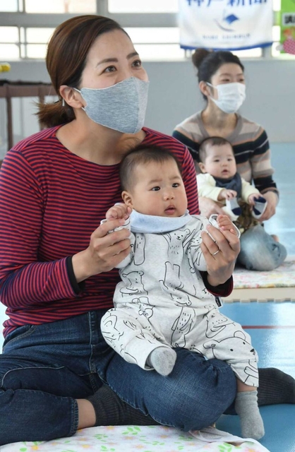 歌に合わせて体を動かす親子＝神戸市兵庫区松原通４、松原児童館