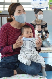 歌に合わせて体を動かす親子＝神戸市兵庫区松原通４、松原児童館