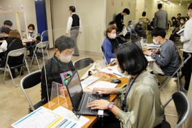 高齢者のワクチン接種予約を手伝う「お助け隊」（右）＝２３日、神戸市中央区役所