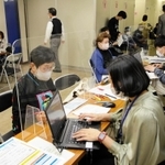 高齢者のワクチン接種予約を手伝う「お助け隊」（右）＝２３日、神戸市中央区役所