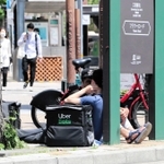注文がなく、座り込んで待機する「地蔵」状態の配達員＝神戸市中央区加納町４