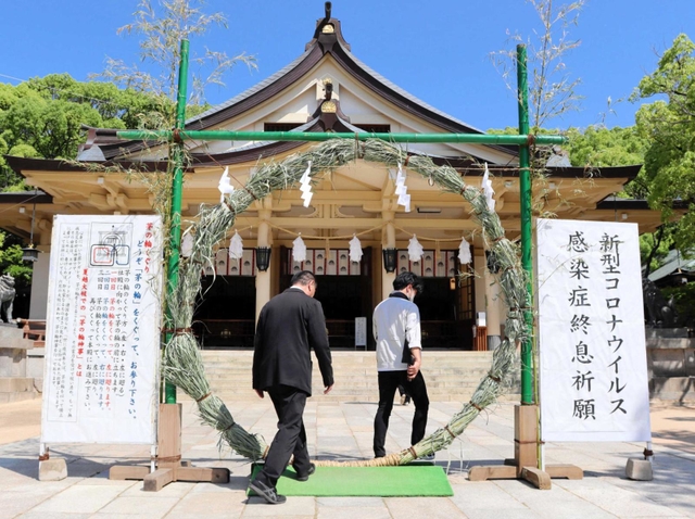 設置された茅の輪をくぐる参拝者＝神戸市中央区多聞通３、湊川神社