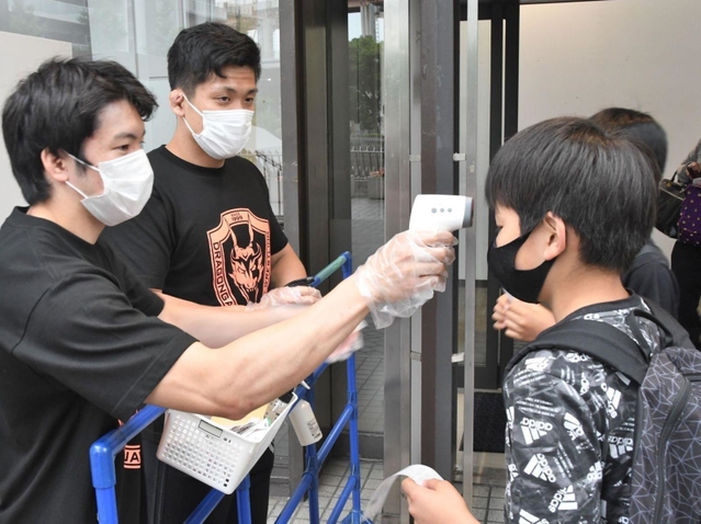 会場入り口で検温と消毒を担うのは、練習生だ＝神戸市中央区浜辺通５、神戸サンボーホール