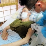 新型コロナウイルスワクチンの接種を受ける寝たきりの男性＝垂水区内（代表撮影）