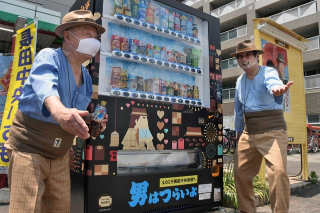 長田中央市場前にお目見えした自動販売機。寅さんにふんしたファンが駆けつけ、設置を祝った＝神戸市長田区六番町８