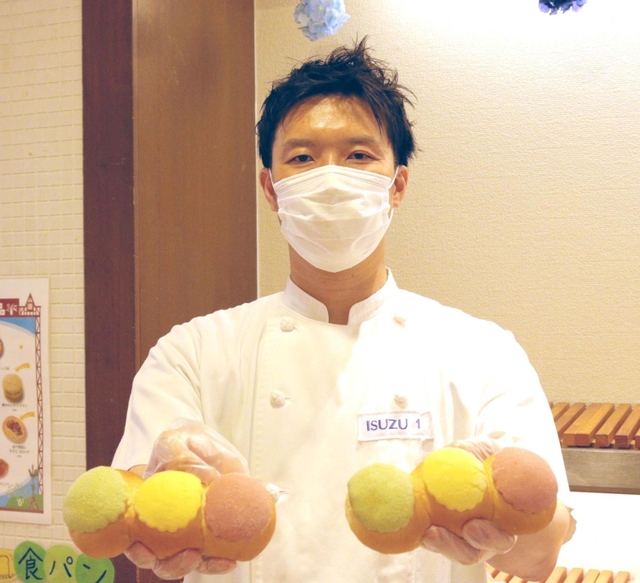 「守ろう！信号パン」を持つイスズベーカリーの井筒大輔代表取締役＝神戸市中央区北長狭通２、イスズベーカリー生田ロード店