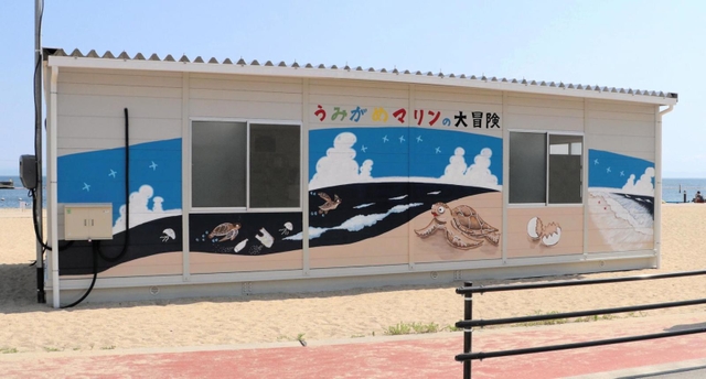 「うみがめマリンの大冒険」のイラストが描かれたプレハブ施設＝神戸市須磨区須磨浦通４