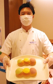 「守ろう！信号パン」を持つイスズベーカリーの井筒大輔代表取締役＝神戸市中央区北長狭通２、イスズベーカリー生田ロード店