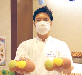 「守ろう！信号パン」を持つイスズベーカリーの井筒大輔代表取締役＝神戸市中央区北長狭通２、イスズベーカリー生田ロード店