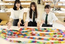 全校生徒が折った鶴を束ねて千羽鶴を作ったボランティア部の部員ら＝神戸市西区伊川谷町、伊川谷高校