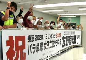 友野有理選手を応援する横断幕を掲げた地域住民ら＝神戸市垂水区城が山１、山陽電鉄滝の茶屋駅