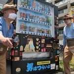 長田中央市場前にお目見えした自動販売機。寅さんにふんしたファンが駆けつけ、設置を祝った＝神戸市長田区六番町８
