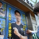 香川真司選手を起用したポスターを垂水署前の掲示板に張る同署員＝神戸市垂水区本多聞３
