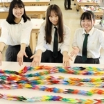 全校生徒が折った鶴を束ねて千羽鶴を作ったボランティア部の部員ら＝神戸市西区伊川谷町、伊川谷高校