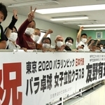 友野有理選手を応援する横断幕を掲げた地域住民ら＝神戸市垂水区城が山１、山陽電鉄滝の茶屋駅
