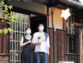 配布されたうちわをあおぎながら涼む来館者＝倚松庵