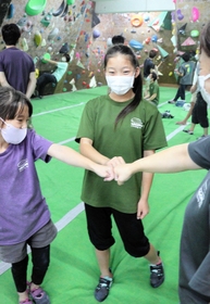 ゴールできると、周囲の人が「ナイス」と声を掛けグータッチを交わす＝神戸市長田区菅原通７、ワゴムクライミングジム