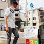 手作りの靴箱を仮置きし、長田区と須磨区の境でビーチサンダルに履き替える長田区の増田匡区長＝神戸市長田区松野通４