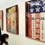 星条旗をモチーフにした日米野球のポスターを見る親子＝東灘区田中町５、コープこうべ生活文化センター