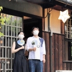 配布されたうちわをあおぎながら涼む来館者＝倚松庵