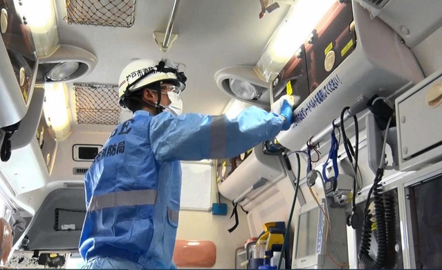 新型コロナ患者の救急搬送後に車内を消毒する救急隊員＝兵庫消防署（神戸市消防局提供）