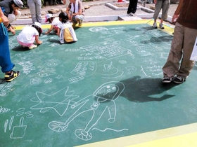 黒板に絵を描いて楽しむ地域住民ら（小國陽佑さん提供）＝神戸市長田区駒ケ林町２、二葉じぞう広場