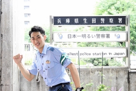 「反射材つけよ」のポーズを取る吉田直輝巡査長＝生田署