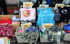 店先に並ぶ古着の子ども服。サイズごとに箱を分けて陳列している＝神戸市灘区赤坂通６