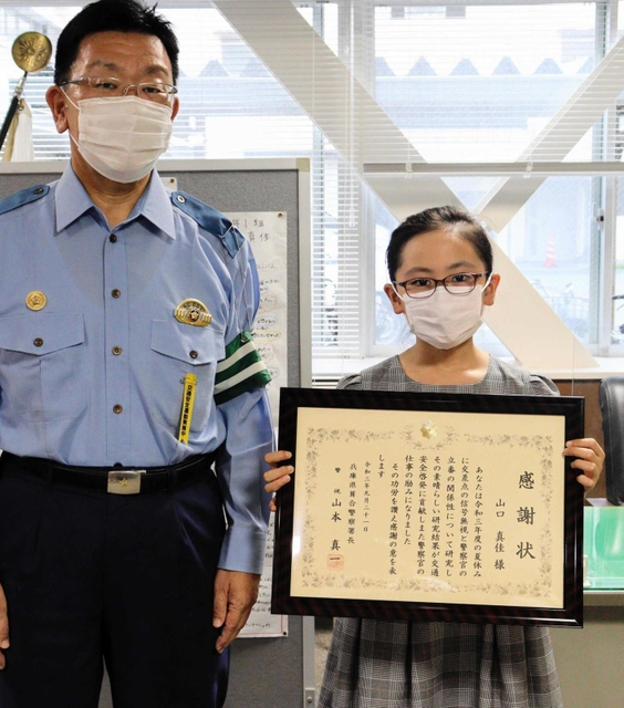 山本真一署長（左）から署長感謝状を贈られた山口真佳さん＝神戸市中央区吾妻通５、葺合署
