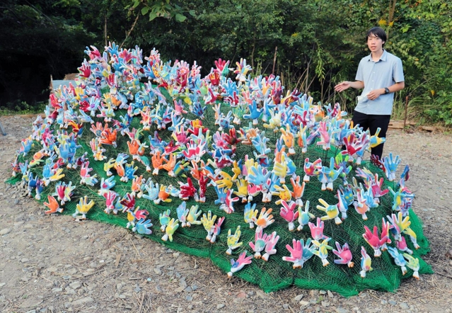 空き地を彩る滑川みざさんのオブジェ。「人々が交流する機会をどんどん作りたい」と話す上野天陽さん＝神戸市長田区東丸山町