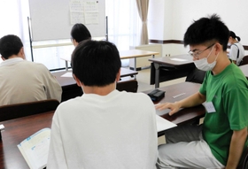 中学生に勉強を教えるボランティアの大学生（右端）＝須磨区文化センター（神戸市須磨区中島町１）