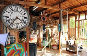 バラックリンの内部で、巣のようなオブジェに座る中村邦生さん。「なんじゃここは！！と体感してほしい」＝神戸市長田区長田天神町７