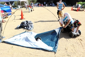 テントは重く、内藤夕貴さんは身を乗り出しながらテントを組み立てていく＝神戸市灘区六甲山町