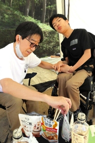 非常食を味わう池田健人さん（右）。おいしさに思わず顔がほころぶ＝神戸市灘区六甲山町