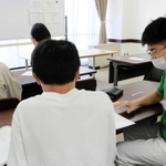 中学生に勉強を教えるボランティアの大学生（右端）＝須磨区文化センター（神戸市須磨区中島町１）