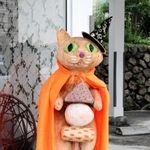 店前に立つ「おでん」を持つ木彫りの猫。耳のカットはＴＮＲの印＝神戸市灘区天城通３