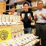 手のひらに収まるマイクロキャンバスの作品をＰＲする志方功一さん（中央）ら＝神戸市中央区三宮町３