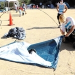 テントは重く、内藤夕貴さんは身を乗り出しながらテントを組み立てていく＝神戸市灘区六甲山町
