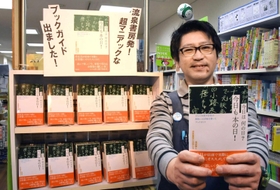 本や映画の出来事を店先の黒板で「今日は何の日」として紹介する逢坂肇さん＝神戸市垂水区陸ノ町１