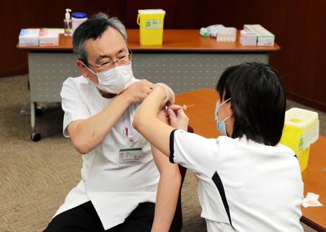ワクチンの３回目接種を受ける神戸大病院の真庭謙昌院長＝中央区楠町７