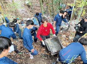 竹やぶに投棄された粗大ごみなどを拾い集める滝川第二高校サッカー部員ら＝神戸市西区平野町