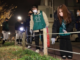 夜の町でごみ拾いをしながら交流する参加者＝神戸市須磨区天神町４