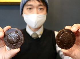 虎が刻まれたチョコと、全粒粉でできた「タイガーメダルクッキーズ」＝神戸市灘区八幡町２、クイーンズジェット