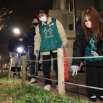 夜の町でごみ拾いをしながら交流する参加者＝神戸市須磨区天神町４