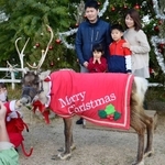 クリスマスの衣装に身を包んだトナカイと笑顔で記念撮影をする参加者＝神戸市中央区港島南町７、神戸どうぶつ王国