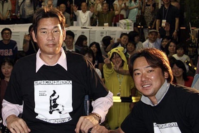 ２００８年に西神戸センター街で開かれた震災復興イベントで写真に納まる仲田幸司さん（左）と安達智次郎さん（西神戸センター街提供）＝神戸市長田区双葉町